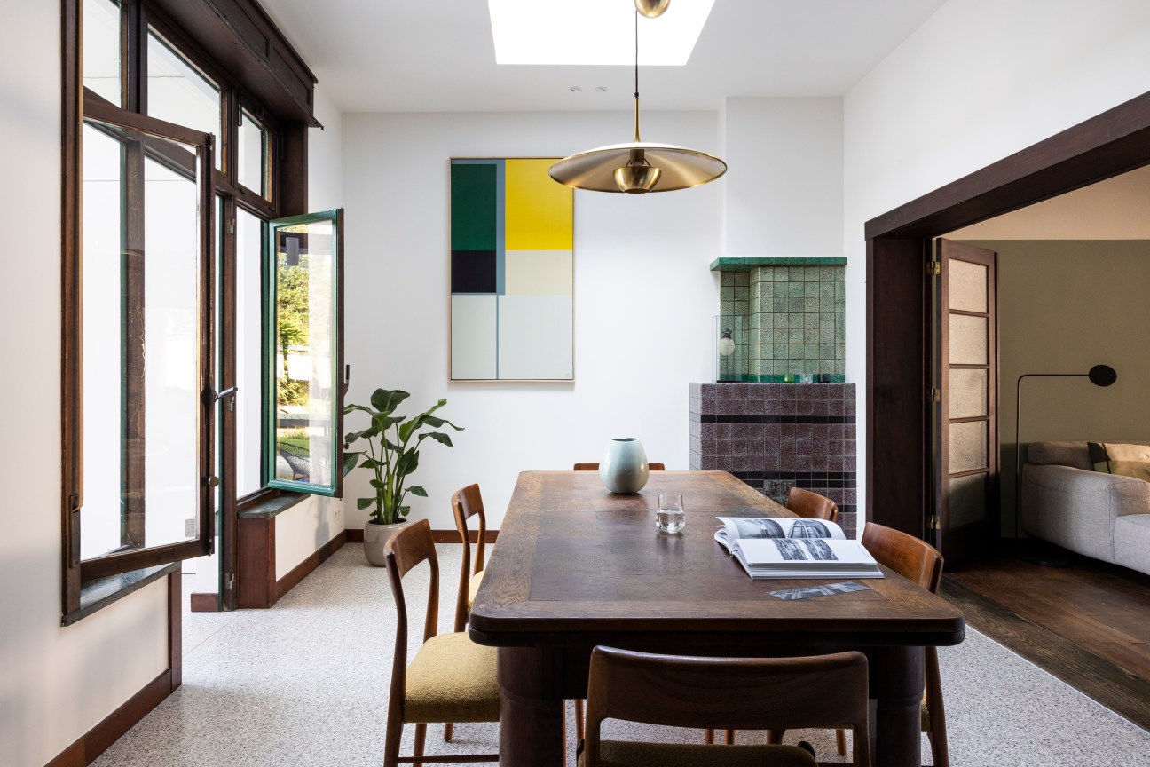 Spacious living room filled with natural light from large windows, featuring period furniture and modern updates