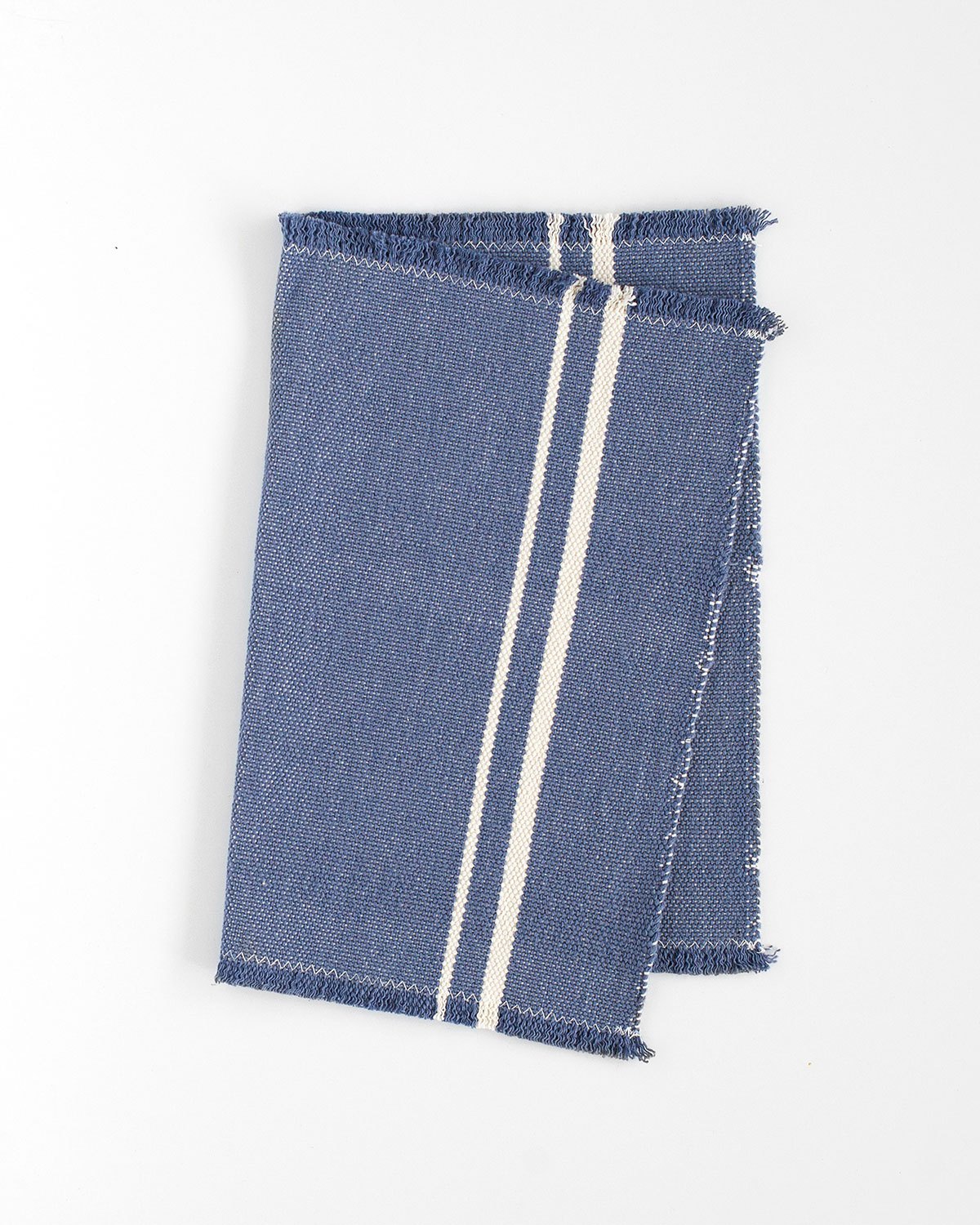 Blue woven textile with white stripes and frayed edges from Barrydale Hand Weavers