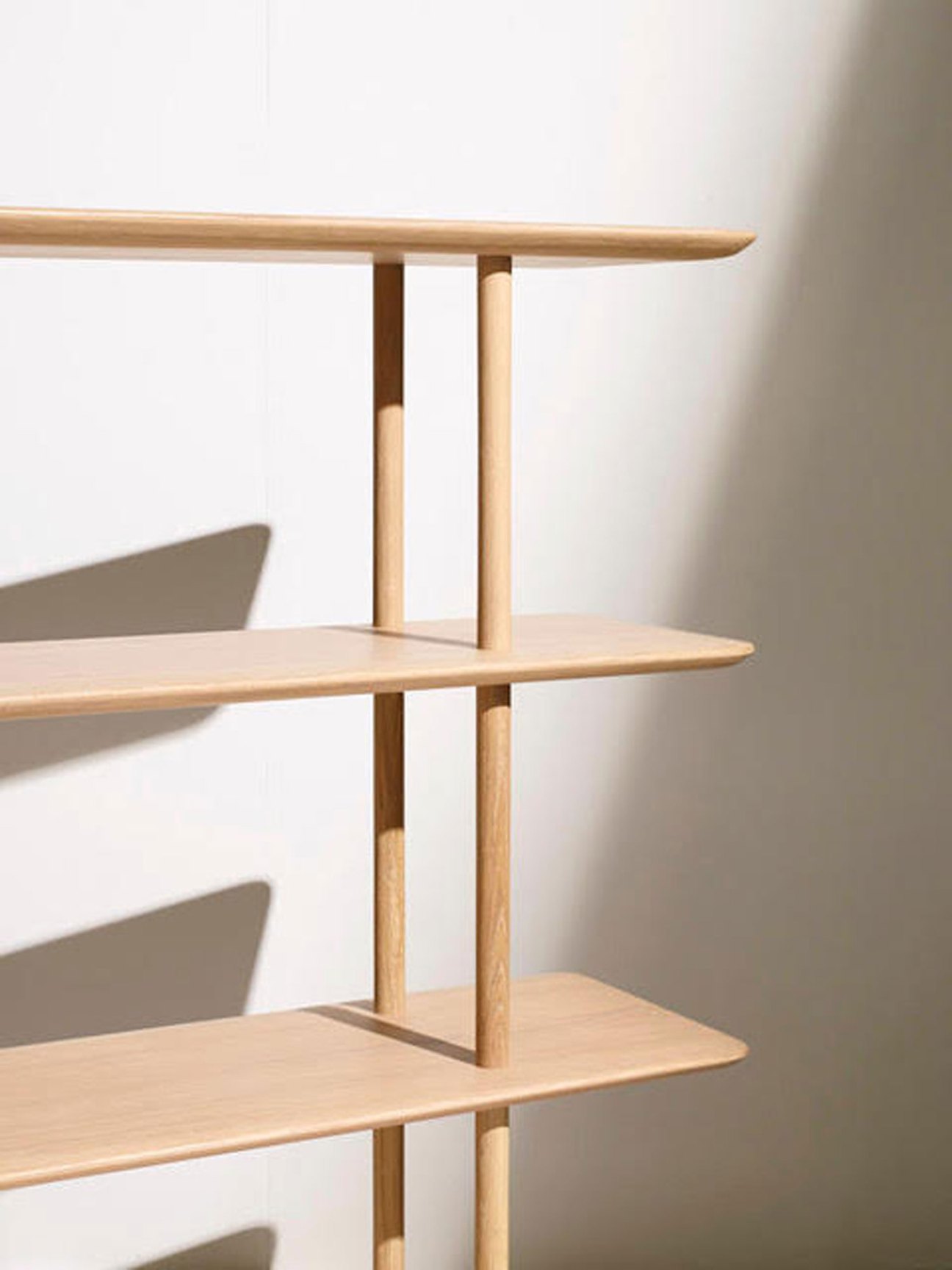 OVO bookcase by Foster + Partners for Benchmark, a light timber shelving unit with curved shelves and vertical supports.