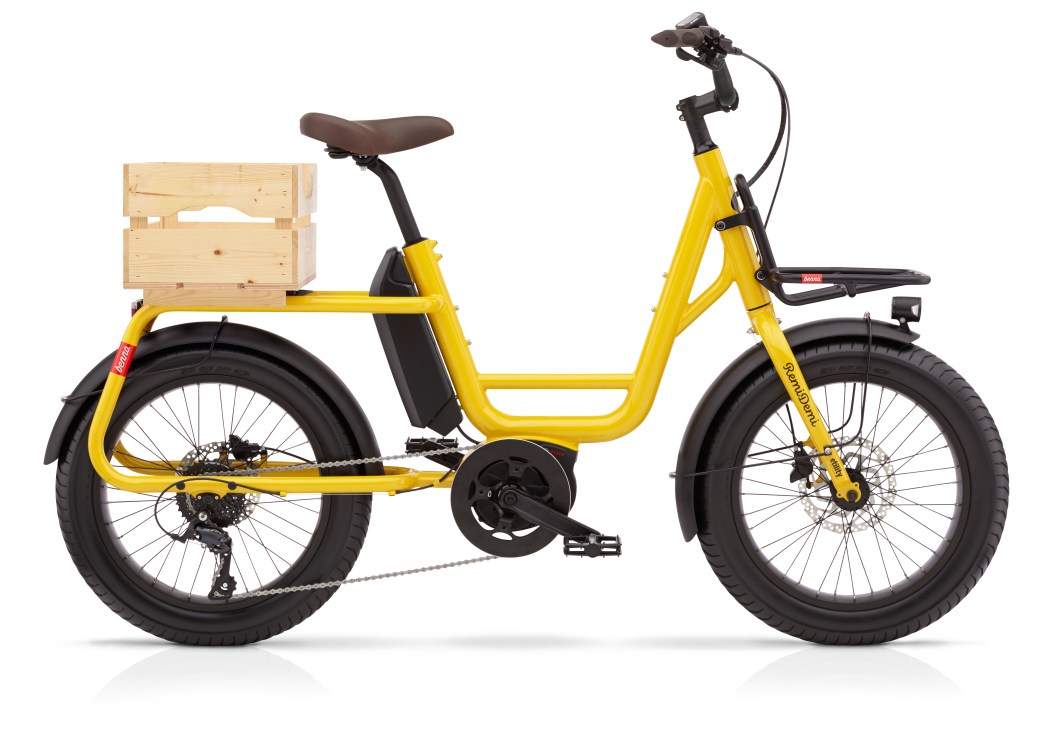 Benno Bikes Remidemi yellow electric cargo bike with wooden crate, brown saddle and disc brakes.