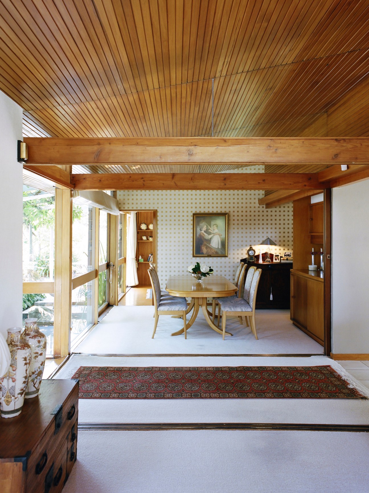 Interior dining room with wooden ceiling, round table, chairs, and sliding shoji screens with translucent panels