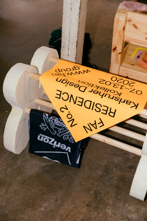 BNAG studio materials including wooden furniture connectors, white tape rolls, and a yellow tag with reversed text.