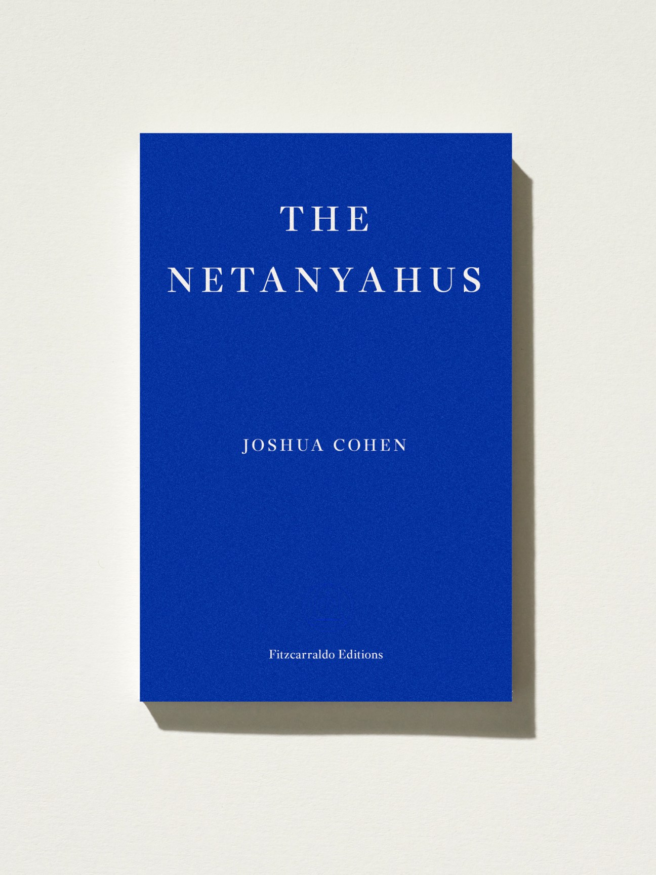 The Netanyahus by Joshua Cohen, a blue book cover with white serif typography published by Fitzcarraldo Editions.