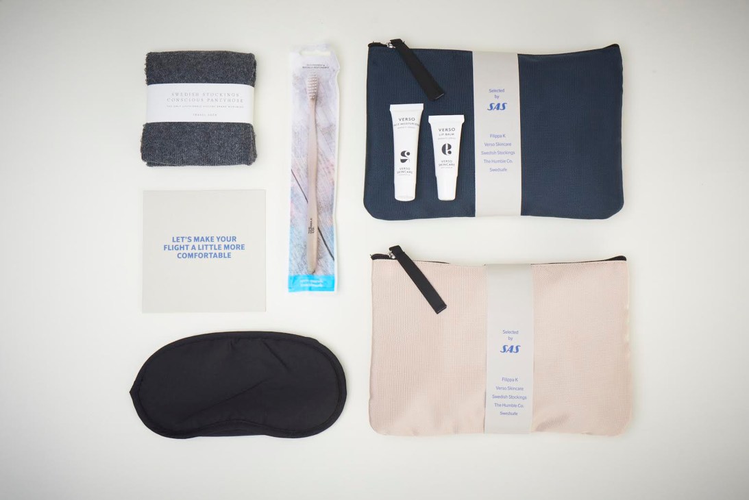 SAS airline comfort kit contents including socks, eye mask, toiletries, and amenities on white background.