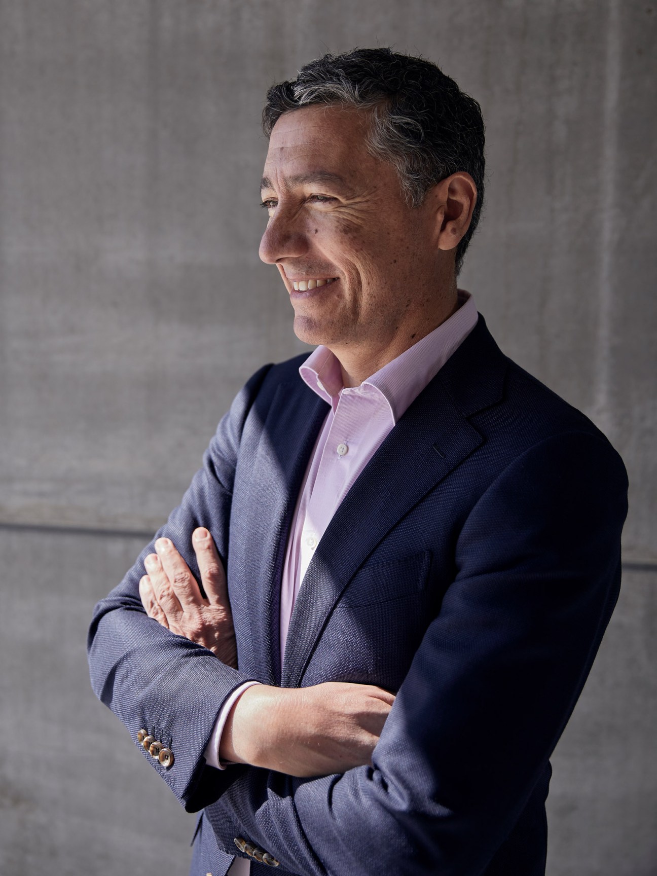Cal Malouf, founder of The Calile Hotel in Brisbane, smiles in profile wearing a navy blazer and pink shirt.