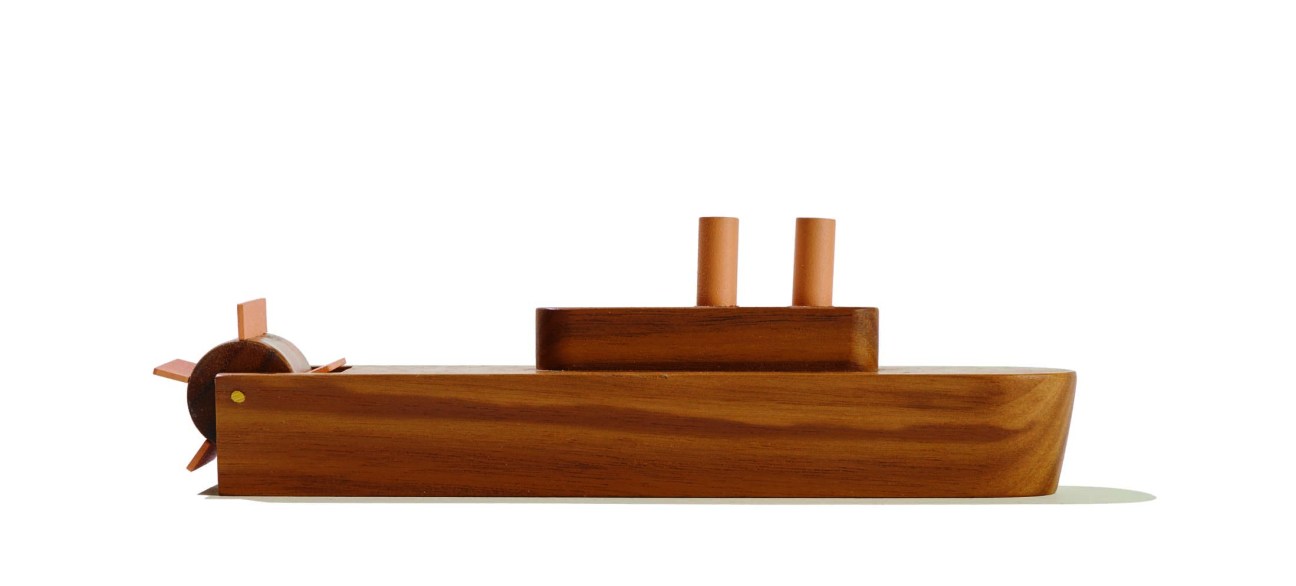Wooden steamboat toy with two smokestacks and a paddle wheel on the side.