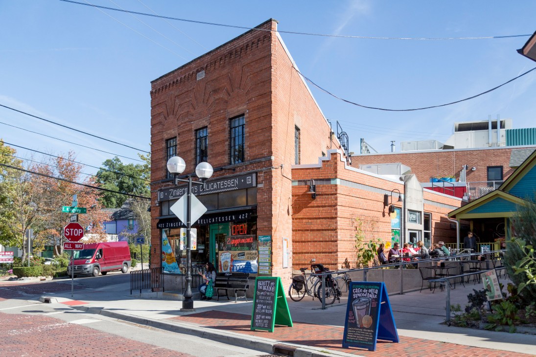 Historic red brick Zingerman's Deli building in Kerrytown, Ann Arbor, with storefront signage and outdoor seating
