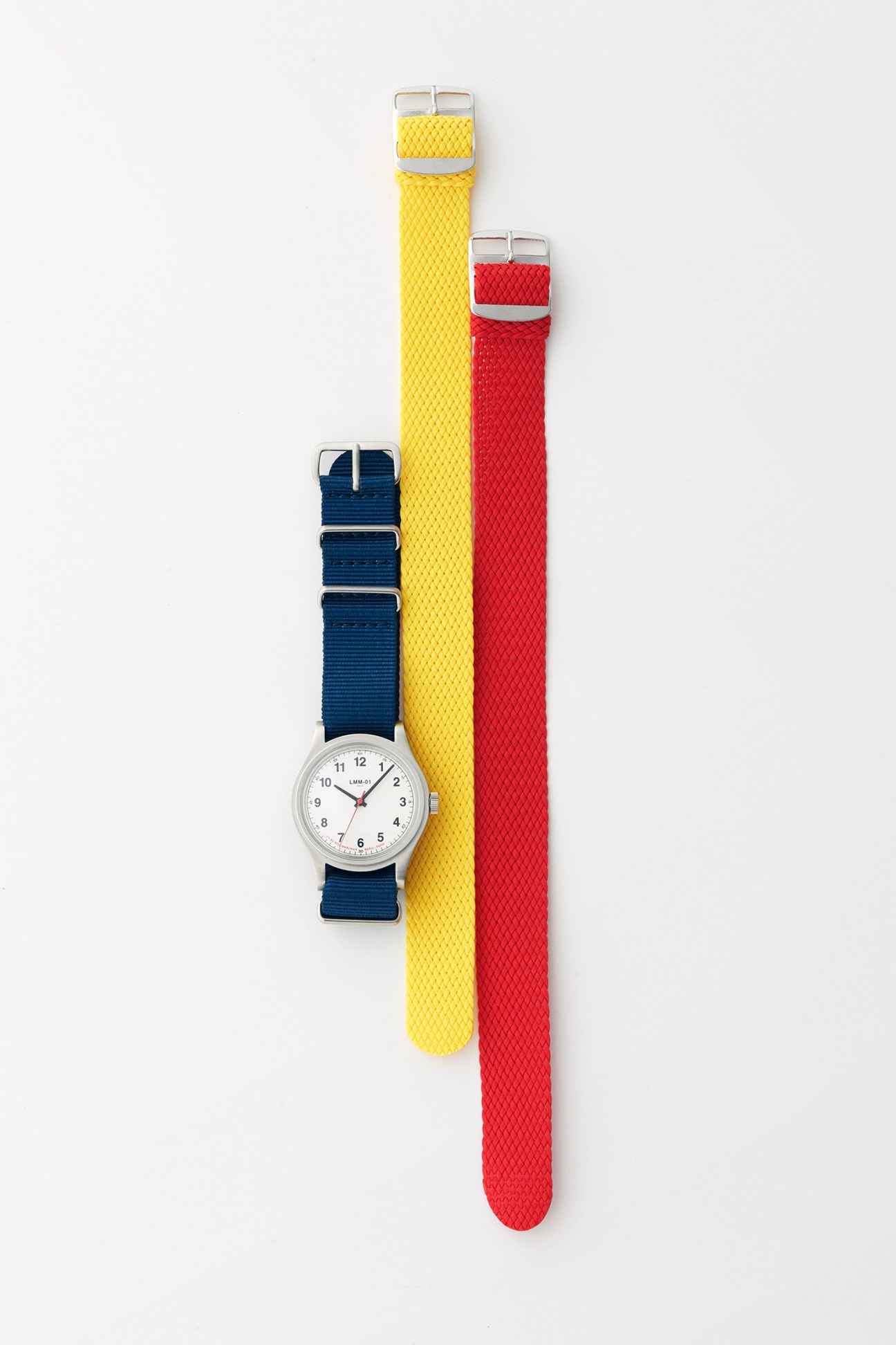 Merci watch with interchangeable fabric straps in navy blue, yellow and red colors displayed against white background.