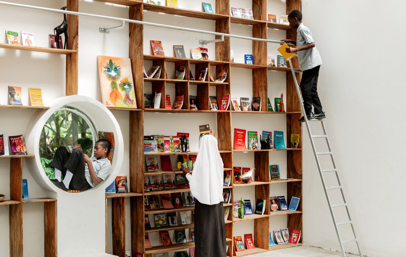 people arranging books on shelves
