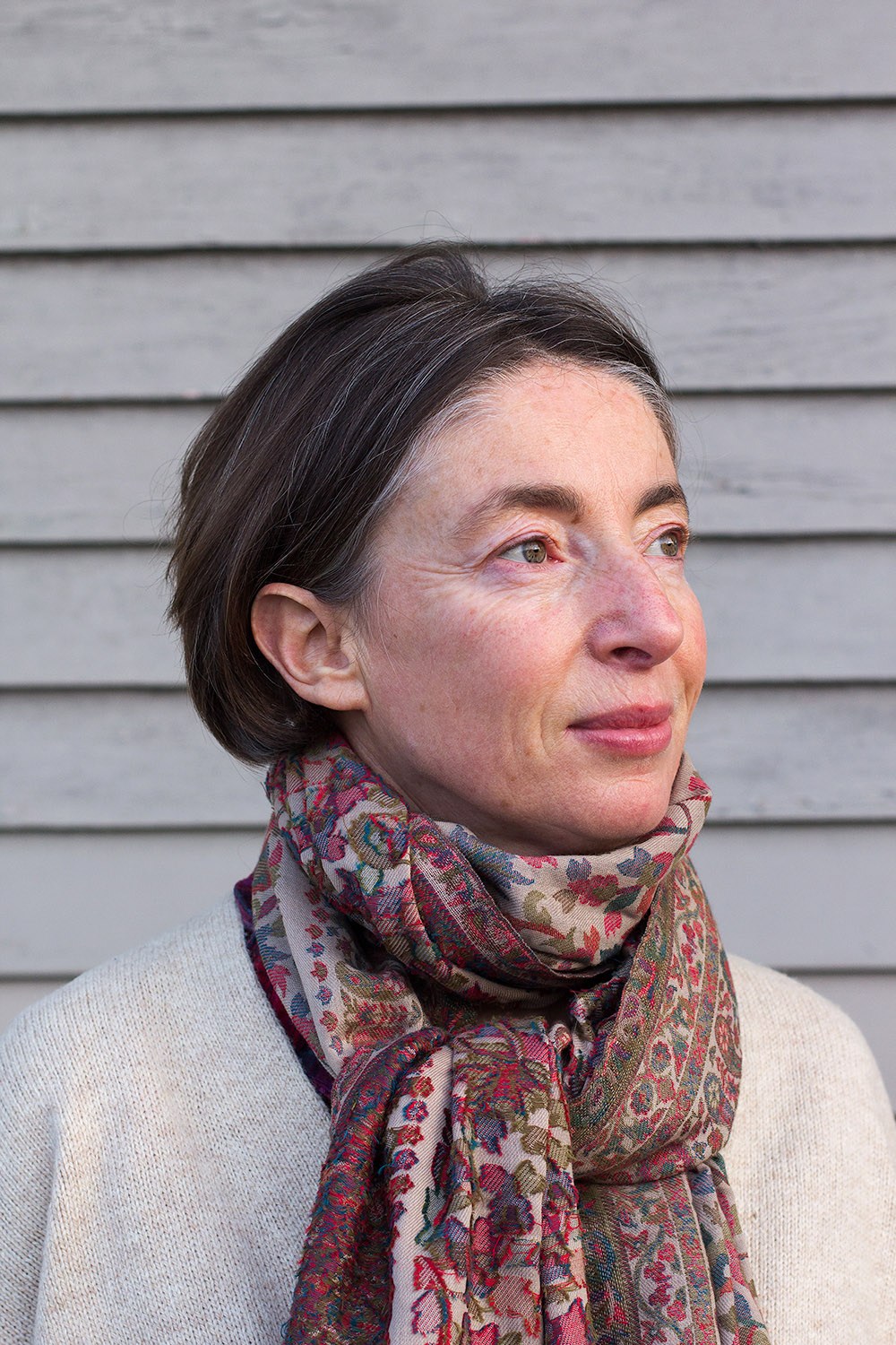 Portrait of Emma Sky, a senior fellow at Yale's Jackson Institute for Global Affairs, against a gray wooden backdrop.