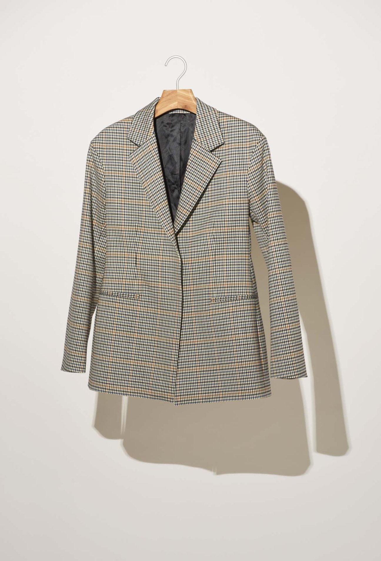 Arket jacket displayed against a white background on a wooden hanger.
