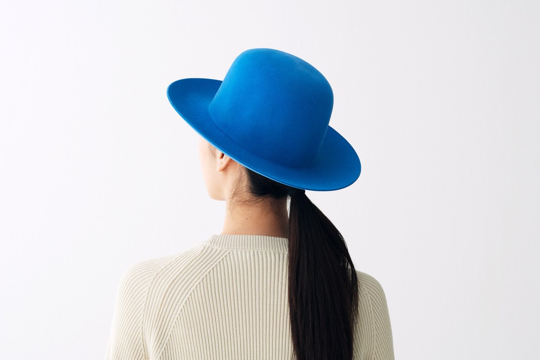 Person wearing a cobalt blue fedora hat from BySju, shown from behind with long dark hair.