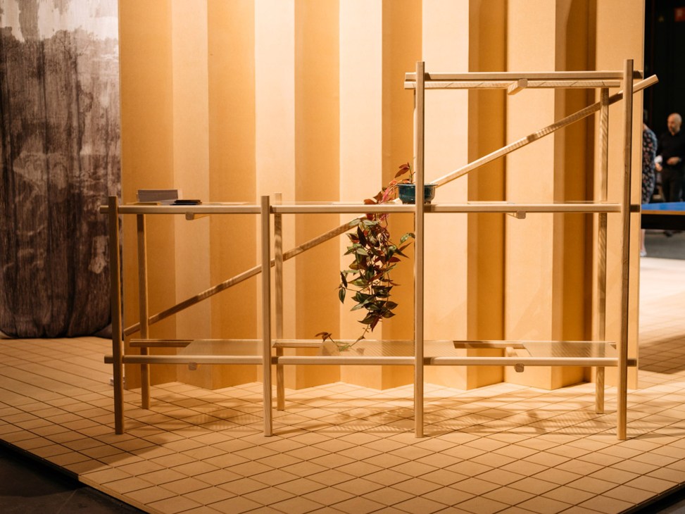 Wooden lattice furniture structure with hanging plant on exhibition floor