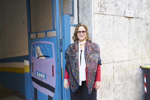 Rebecca Spitzmiller stands in front of a blue door marked AMMA in a Rome street.