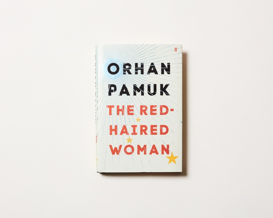 Book cover of 'The Red-Haired Woman' by Orhan Pamuk with radiating blue lines and gold stars on white background.