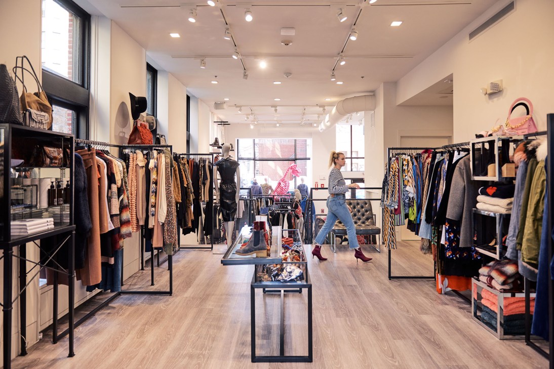 Minimalist retail interior of All Too Human boutique in Boston with clothing racks and large windows.