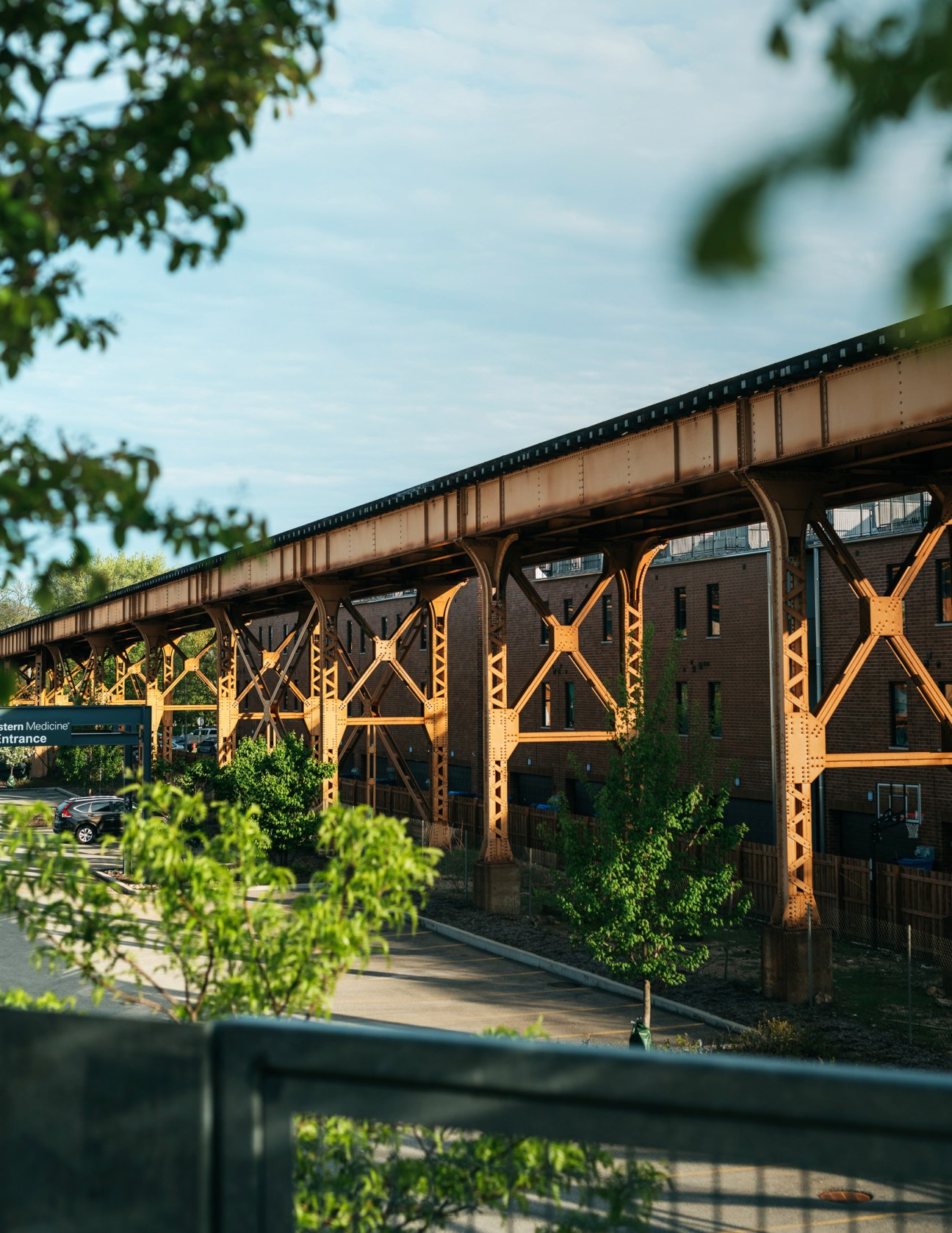 The 606 elevated path in Chicago with yellow metal support beams and brick buildings underneath.