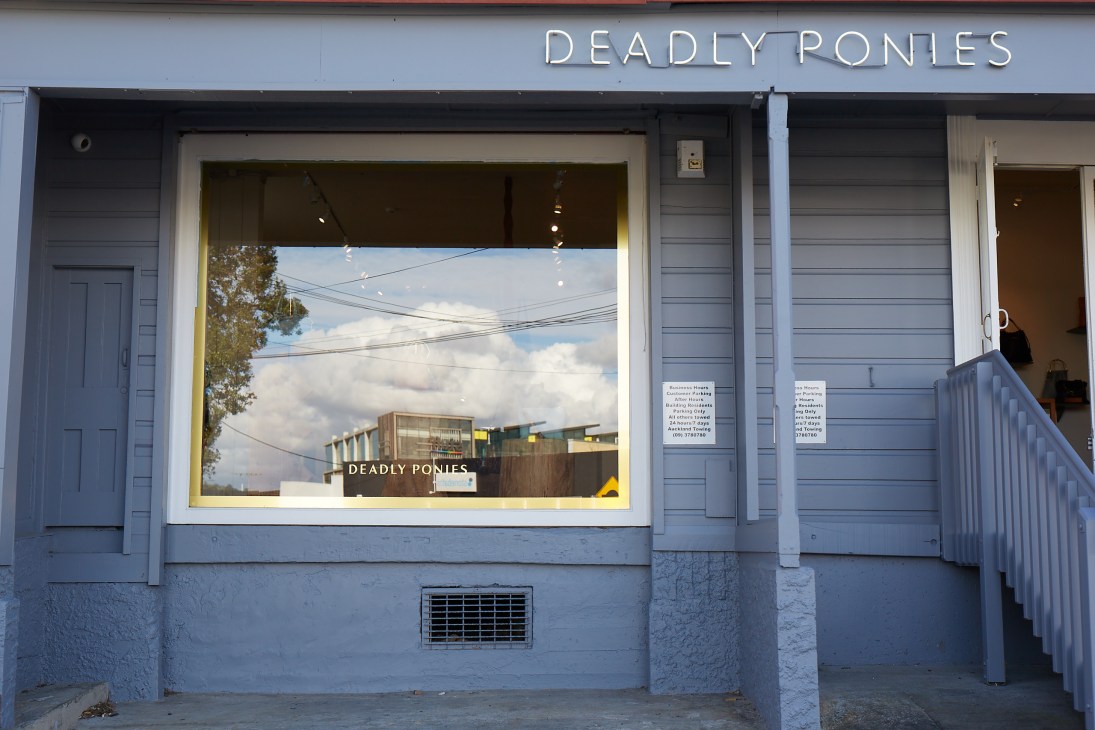 Storefront of Deadly Ponies shop in Ponsonby with neon sign and large display window.