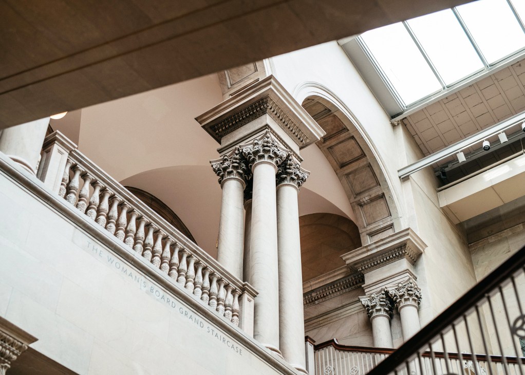 Classical interior with ornate Corinthian columns and arched ceiling at The Art Institute of Chicago.