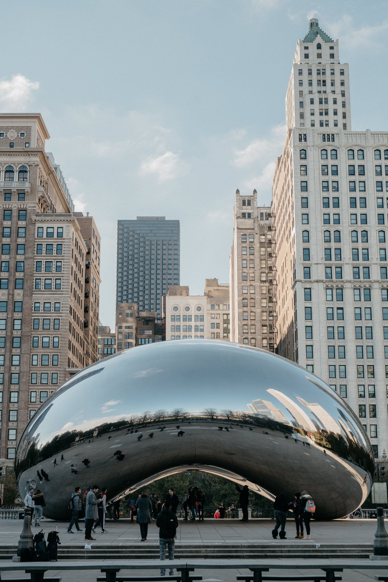 Cloud Gate sculpture in Millennium Park with Chicago skyscrapers and visitors in the background
