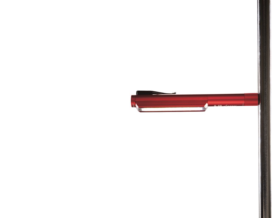 Nebo pen torch with red metallic finish and magnetic base attached to metal surface.