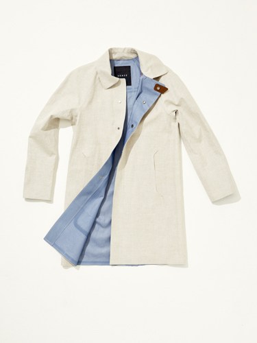Cream-colored trench coat displayed open, showing light blue lining and brown toggle buttons.