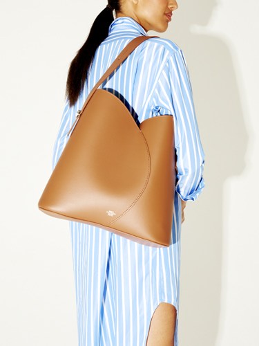 Woman wearing striped shirt carrying a tan leather tote bag by Object Particolare.