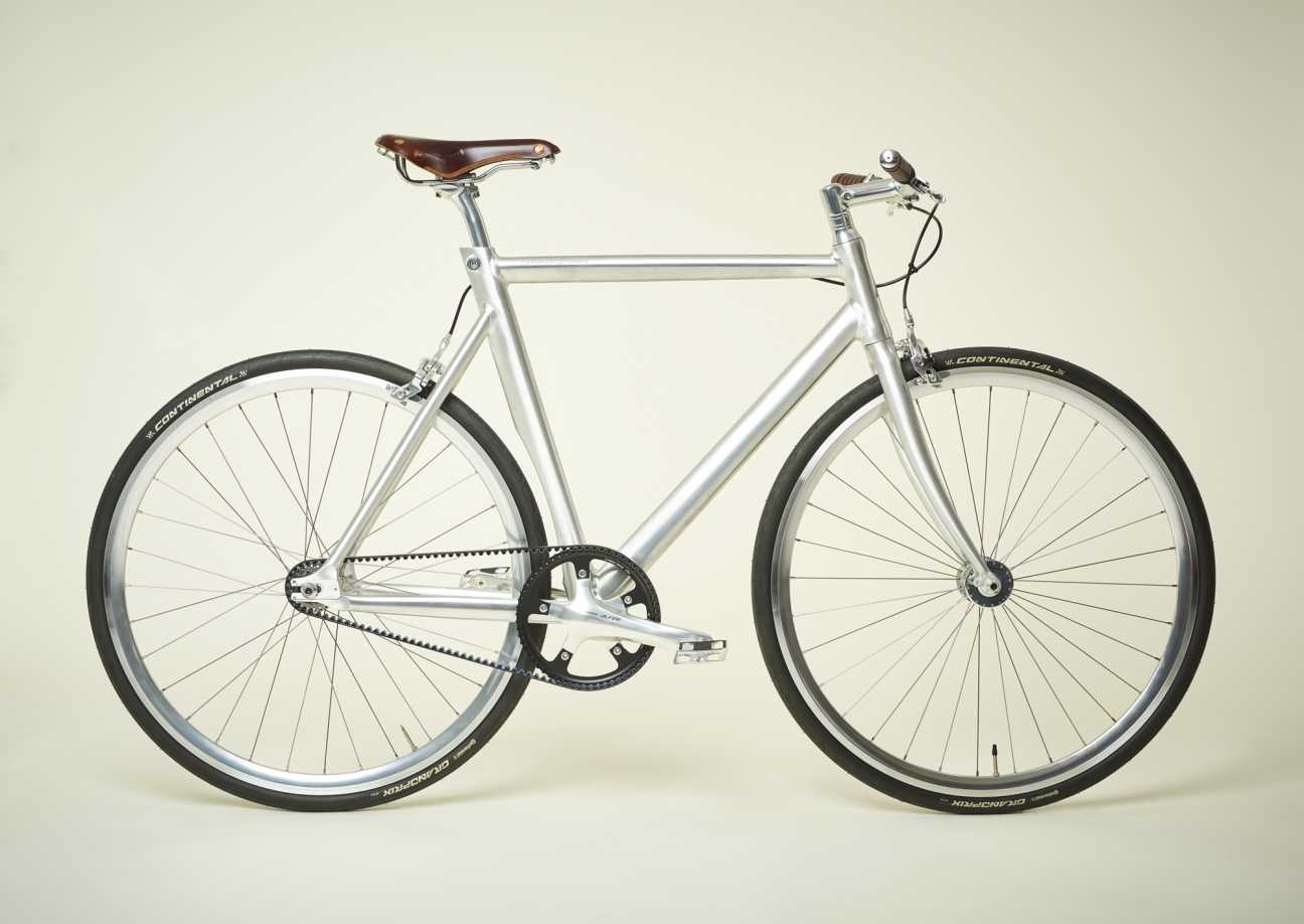 Silver lightweight aluminium single-speed bike by Schindelhauer with brown leather saddle and black Continental tyres.
