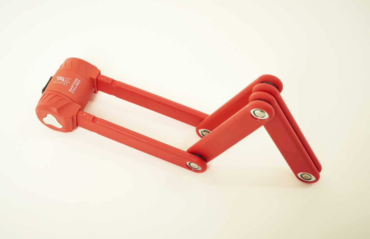Red foldable bicycle lock from Martone Cycling Co with articulated arms and metal eyelets.