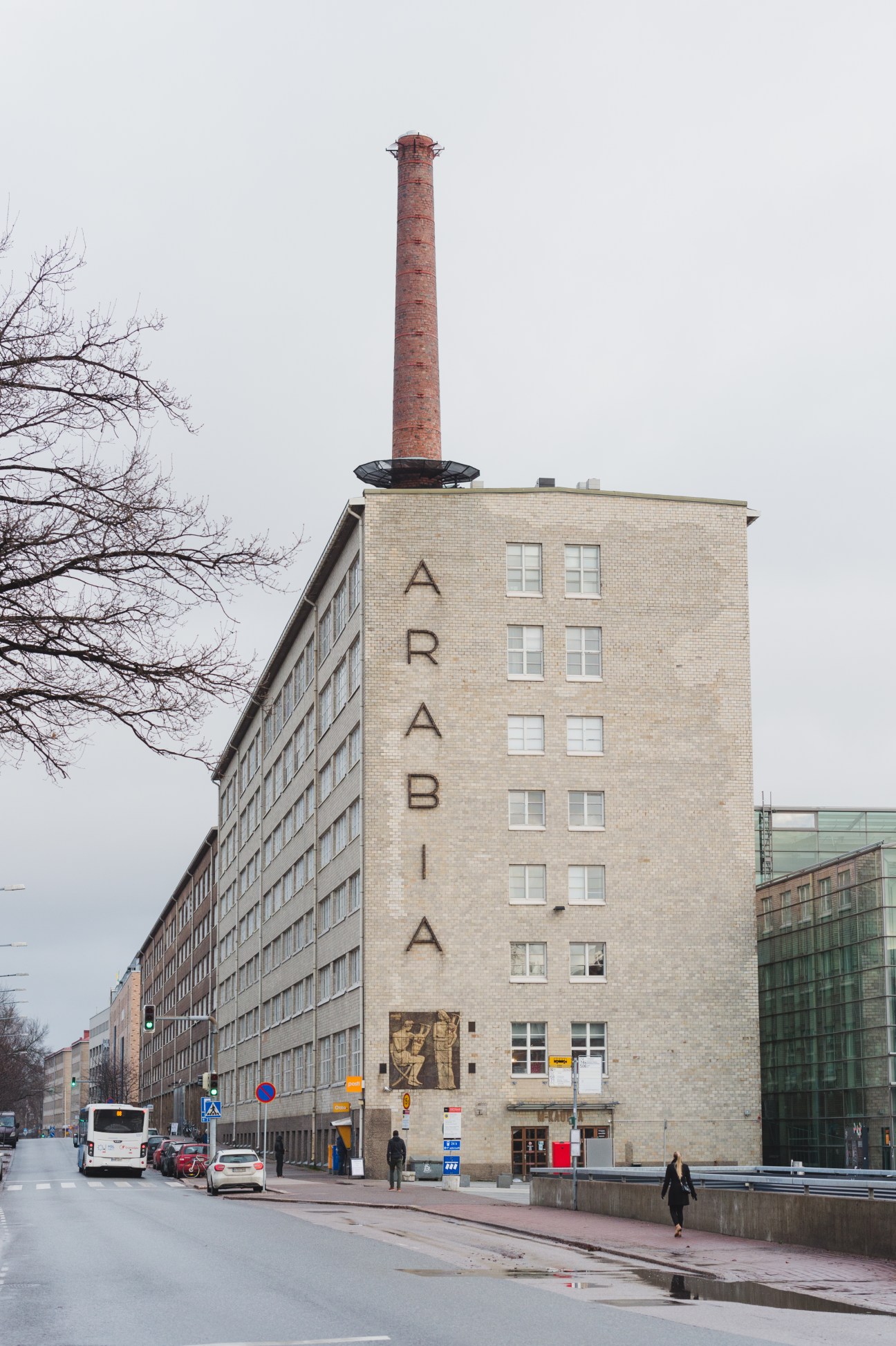 Tall brick building with "ARABIA" letters on facade and red chimney on roof