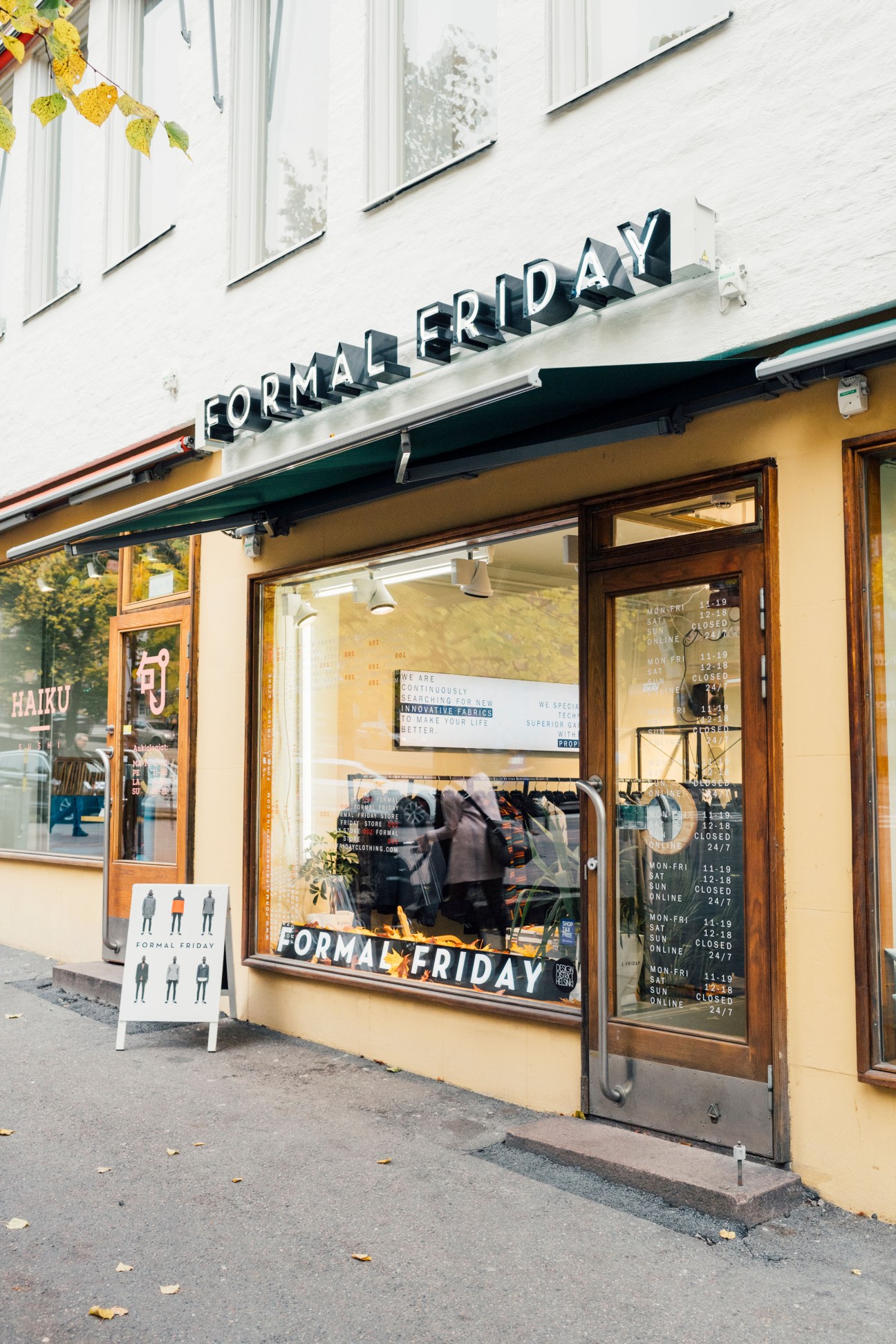 Formal Friday storefront in Helsinki with neon signage, yellow facade, and clothing displayed in window.