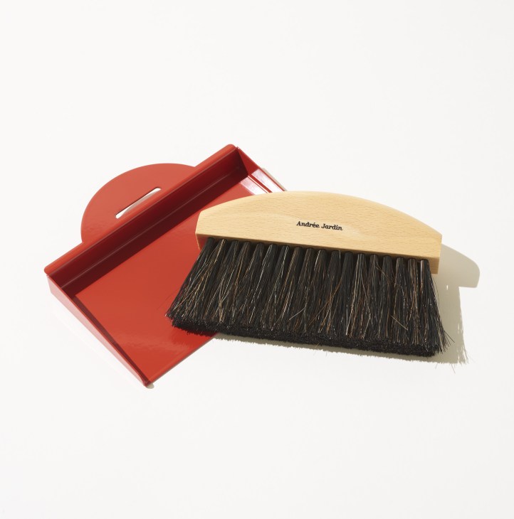 Red dustpan and natural wood brush with black bristles by Andrée Jardin.