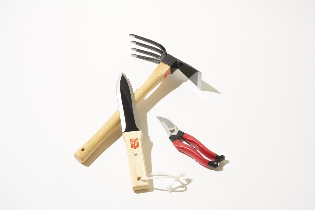 Japanese gardening tools including a rake, hoe, and pruning shears with wooden handles.