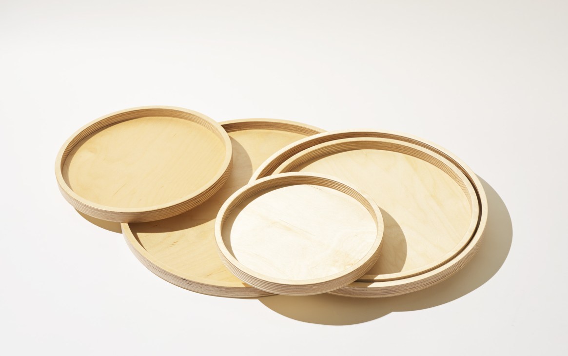 Five nested wooden serving trays of increasing sizes by Margaret Howell, made from birch plywood.
