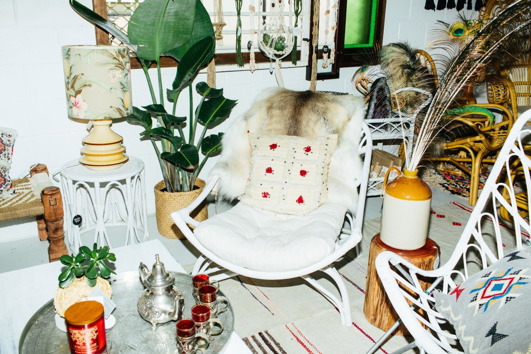 Interior of The Beach Furniture Burleigh Showroom with white rattan chair, decorative objects and plants