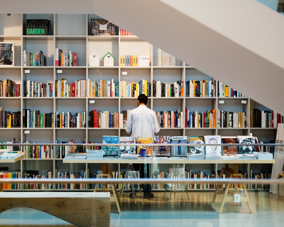 Person browsing books on shelves at Inform Interiors in Vancouver.