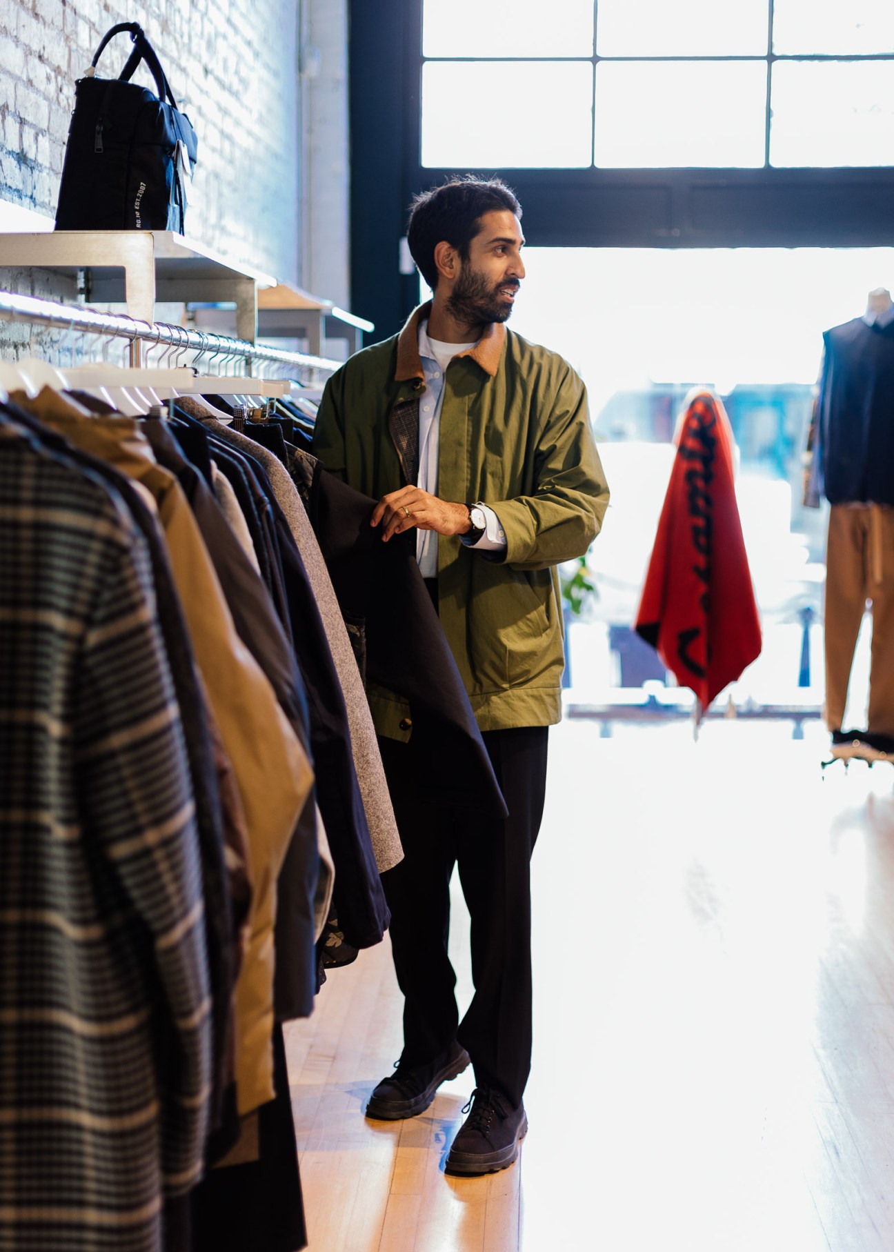 Saager Dilawri browsing clothing racks at a Gastown fashion retail store.