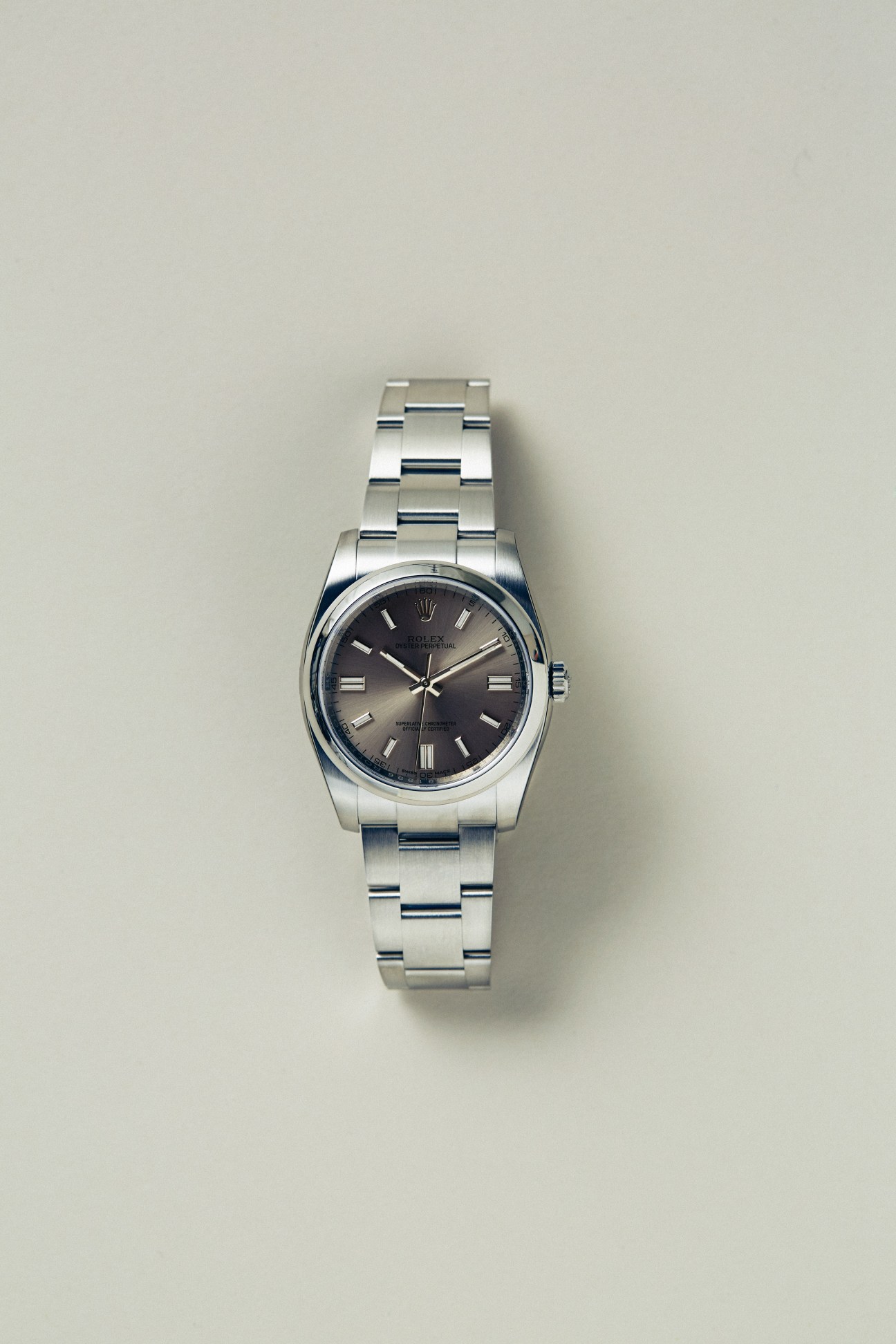 Silver-toned wristwatch with dark dial and metal bracelet on white background.
