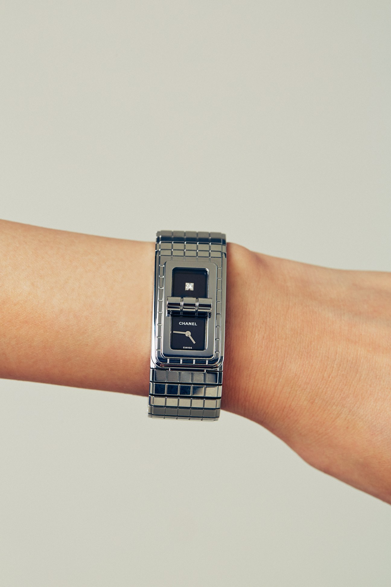 Chanel watch with black dial and steel bracelet worn on wrist
