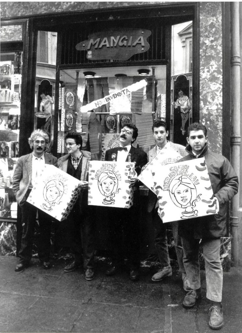 Black and white photograph of five men holding artwork outside the Mangia delicatessen storefront in Palermo.