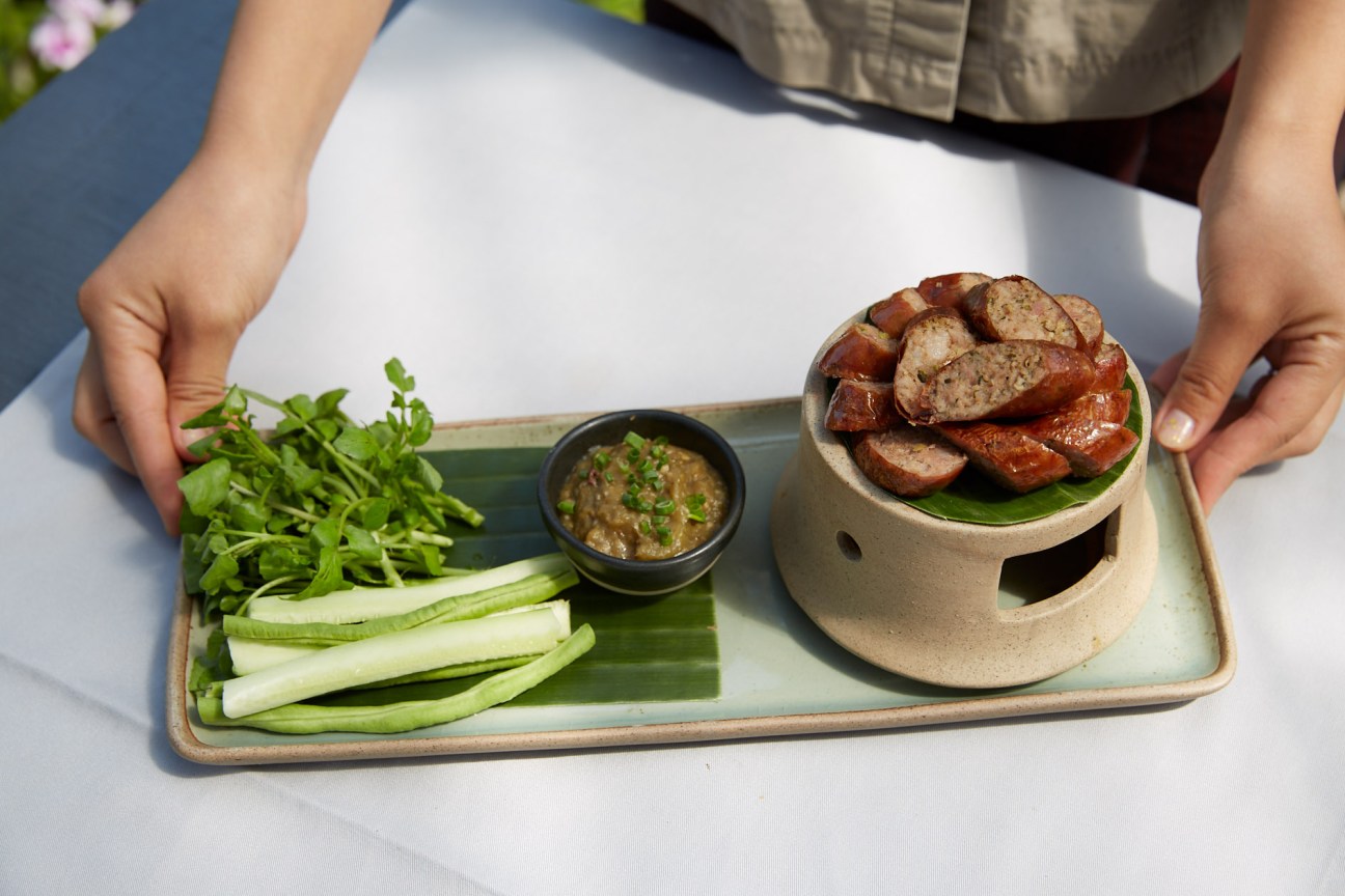Laotian sausage dish served with fresh herbs and dipping sauce at Manda de Laos restaurant.