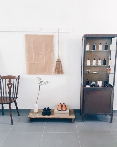 Interior of A Beautiful Store showing minimalist display with wooden furniture, vintage chair, and organized shelving.