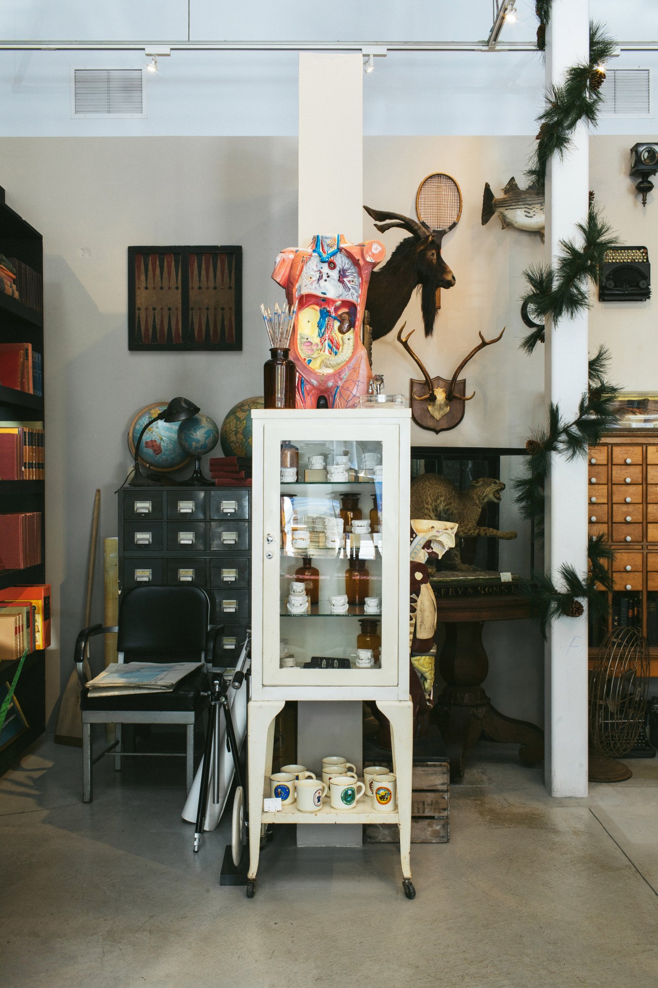 Eclectic shop display featuring taxidermy, vintage furniture, globes, and decorative objects curated at Hound and Quail.