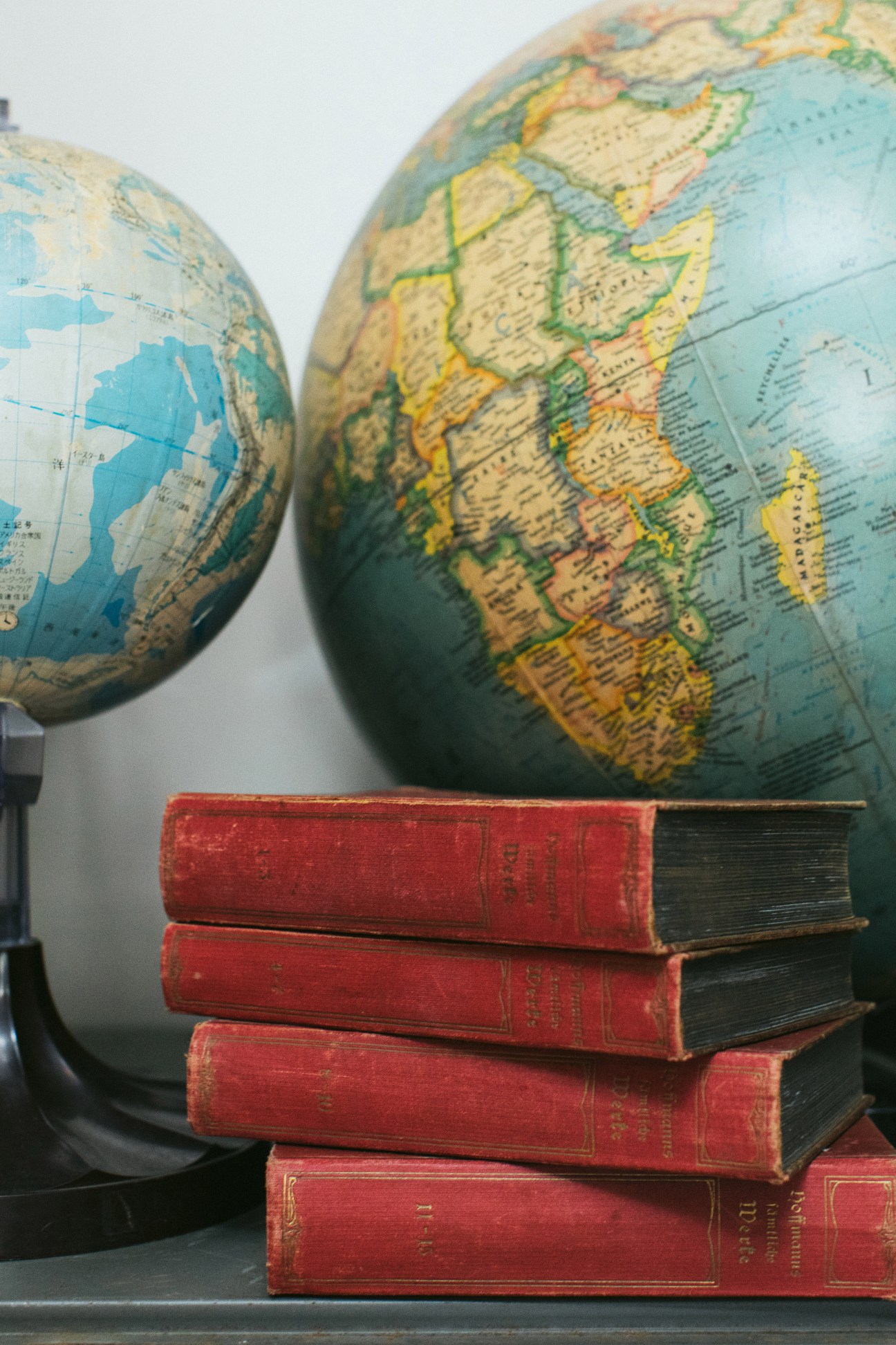 Vintage globes and antique red books displayed at Hound and Quail curiosity shop in Honolulu.