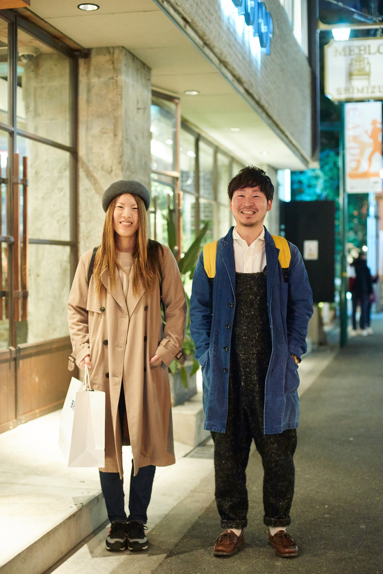 Two young people smiling in an indoor shopping arcade in Osaka.
