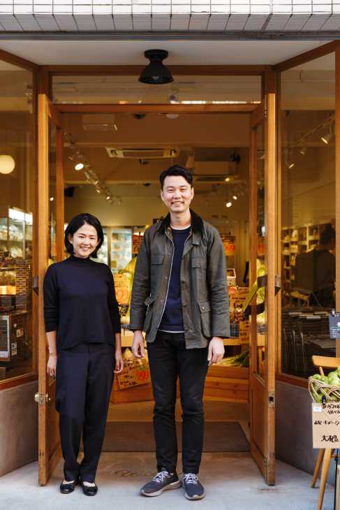 Maya Yatabe and Bing Bai stand smiling in the wooden-framed doorway of Food & Company, their Tokyo grocery shop.