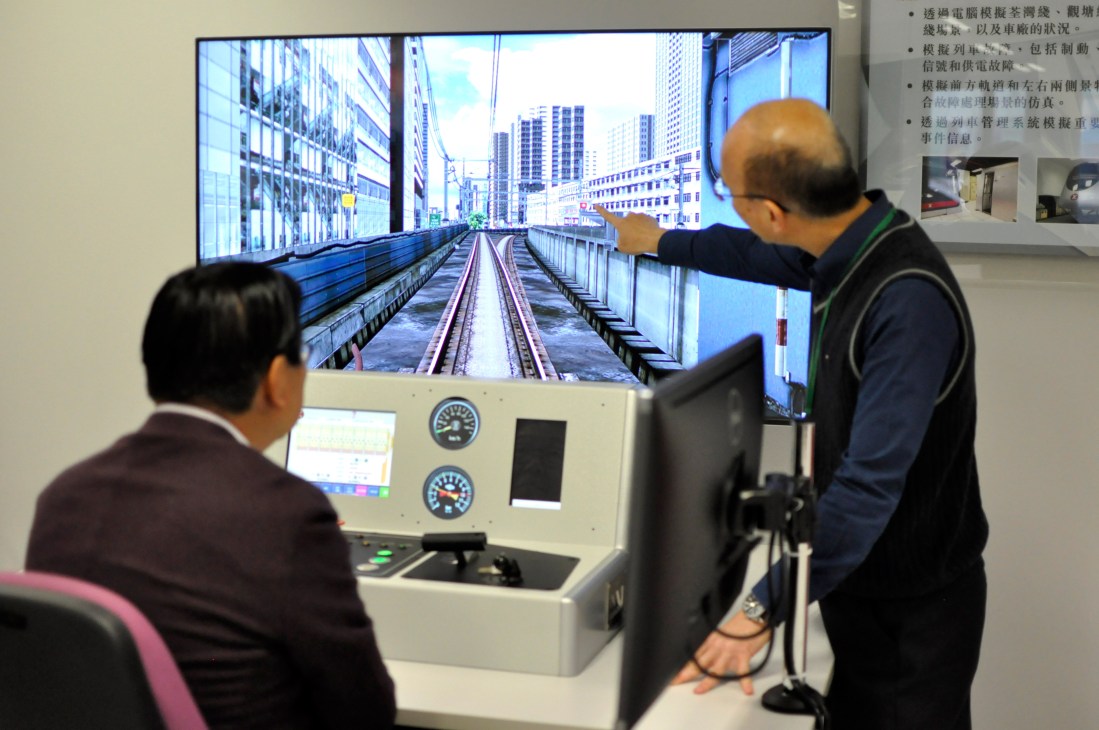 Two people using an MTR train simulator at the operator's training academy in Hung Hom, Hong Kong.