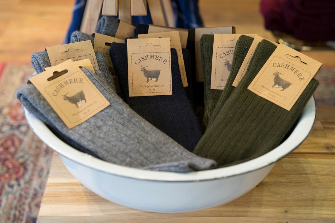 Cashmere socks in various colors displayed in a white bowl at Scout retail store.