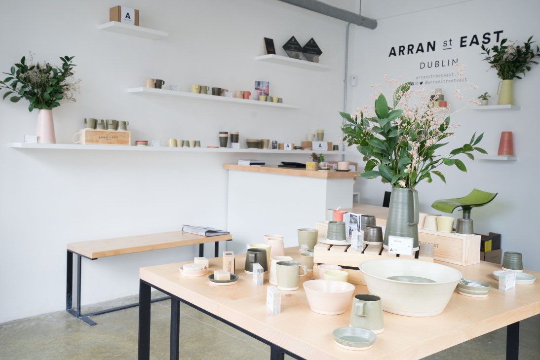 Arran Street East pottery shop interior displaying hand-thrown ceramic vessels on wooden tables and shelves.