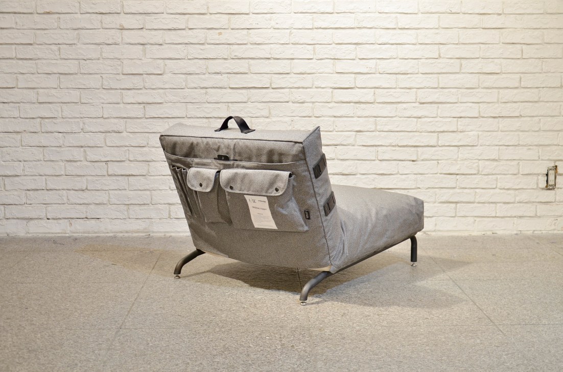 Gray lounge chair with multiple pockets and leather details, featuring technical Cordura fabric.